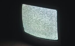 gray crt tv turned on in a dark room