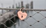 red heart padlock on gray metal fence during daytime