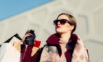 shallow focus photography of woman holding shopping bags during day