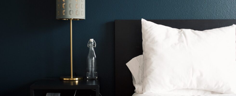 gray table lamp beside white bed pillow