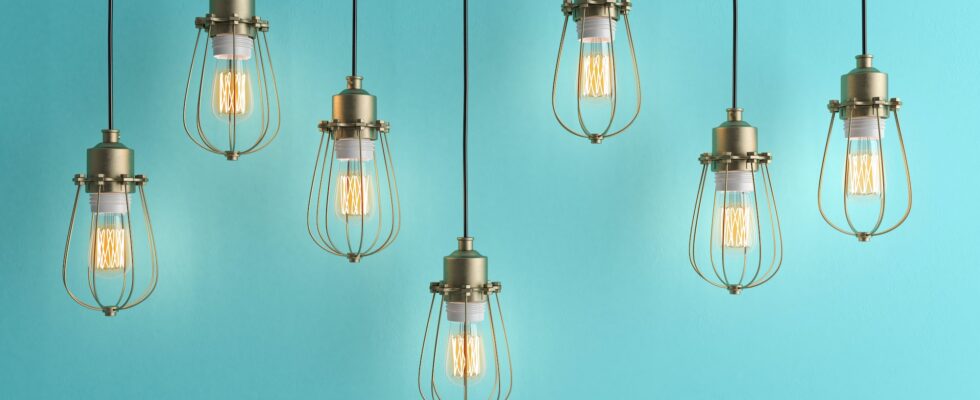 Seven vintage lamps hanging from the ceiling with blue wall 3D renderind