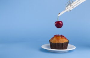Robot preparing sweet cupcake with cherry, blue background