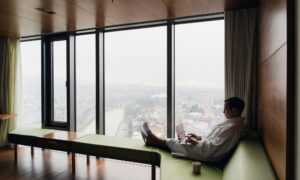 Attractive Man enjoying his morning coffee on his computer at his hotel room