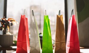 Close up colorful shopping bags on table with big window on back