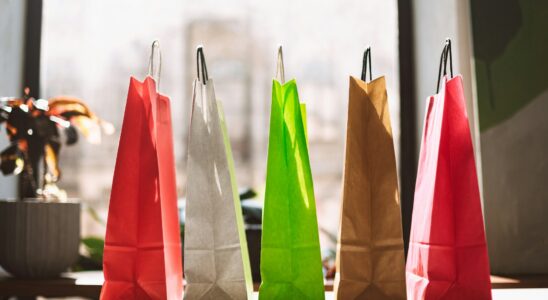 Close up colorful shopping bags on table with big window on back