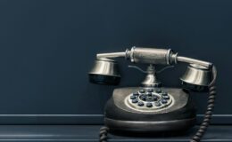 black and brown rotary phone near gray wall