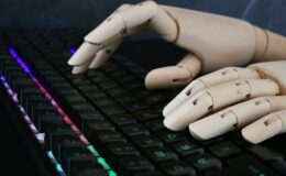 AI artificial intelligence concept - robot hands typing on lit keyboard