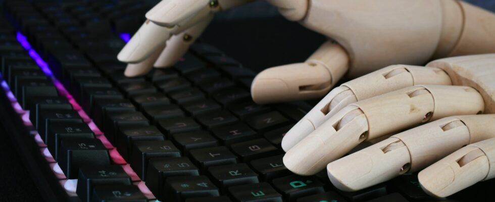 AI artificial intelligence concept - robot hands typing on lit keyboard