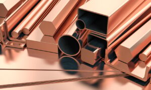 Copper tubes and different profiles in warehouse background. Different copper metal rolled products.