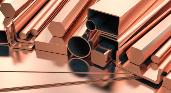 Copper tubes and different profiles in warehouse background. Different copper metal rolled products.