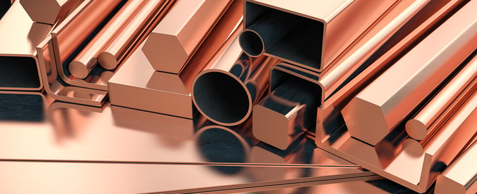 Copper tubes and different profiles in warehouse background. Different copper metal rolled products.