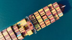 Aerial top view of cargo ship carrying container and running for export goods from cargo yard