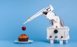Robot cooking dessert, decorating sweet cupcake with fresh cherry