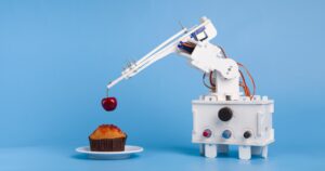 Robot cooking dessert, decorating sweet cupcake with fresh cherry