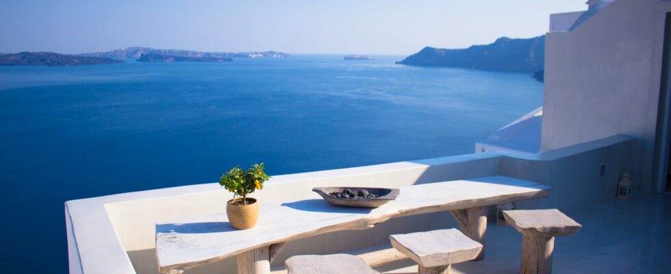 bench and dining table near body of water under calm sky