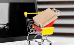 Online shopping concept. Shopping cart, laptop on the desk