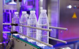The PET bottles in the rail on the conveyor belt for filling process in the drinking water factory.