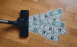 a pile of money sitting on top of a wooden floor