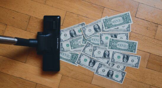 a pile of money sitting on top of a wooden floor