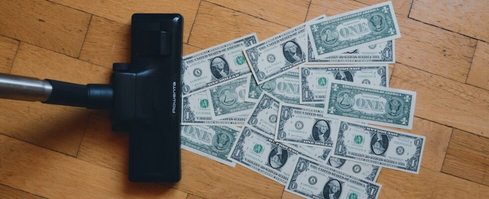 a pile of money sitting on top of a wooden floor